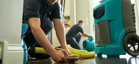 tech repairing flooded kitchen
